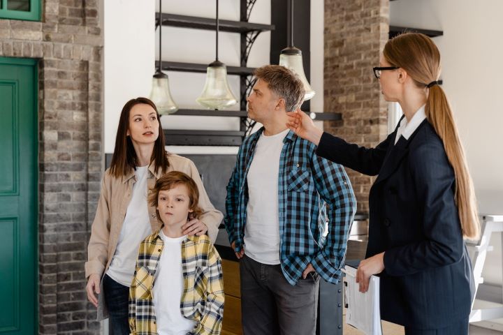 a realtor showing a home to a family