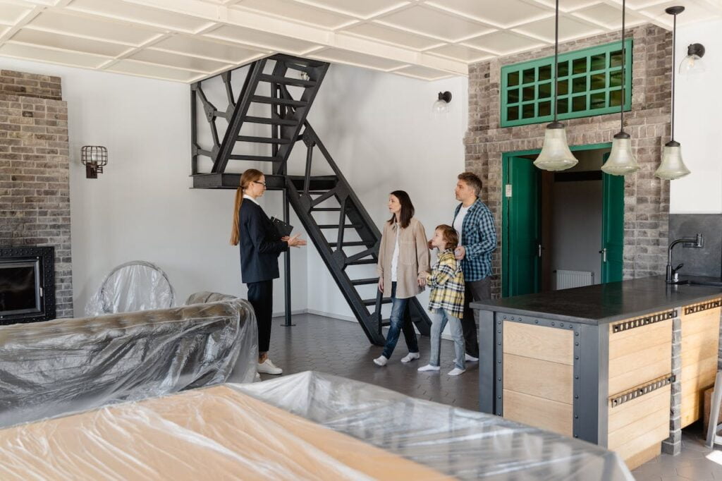 A man, woman, and child speak with a real estate agent