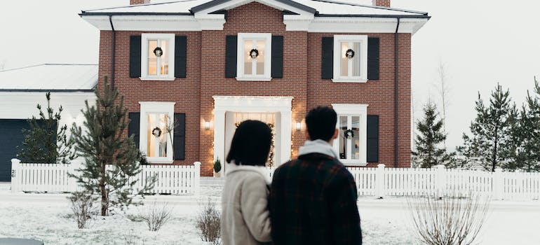 A couple in front of their home