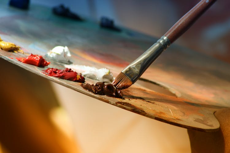 Close-up of a paint palette and a paintbrush.